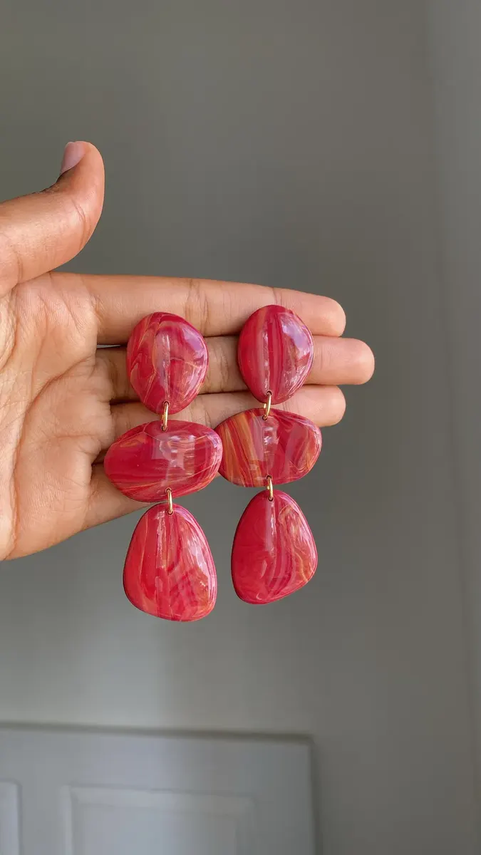 Aretes Aurora: piezas rojas jaspeadas en la mano