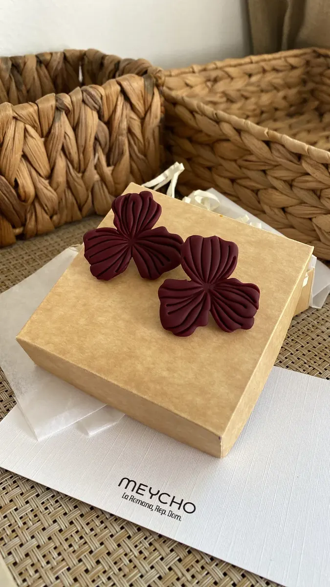 Aretes Burgundi: flores color vino sobre una caja